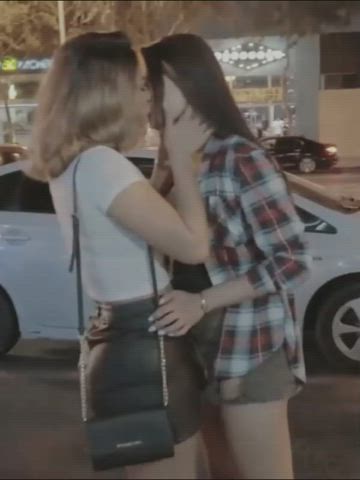 Latina and Asian girl make out on a busy street