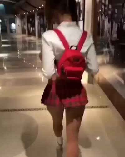 Cute girl in schoolskirt is walking in the stores