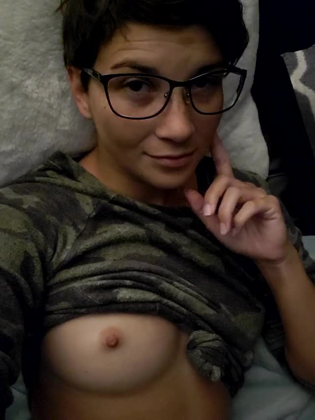 Bed head in glasses laying on the couch with a titty out