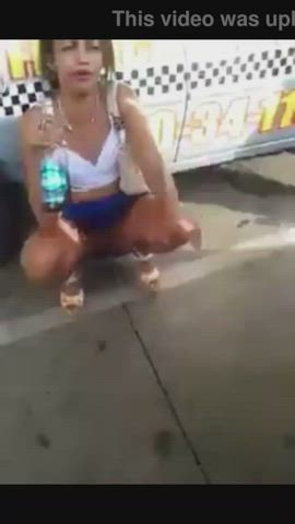 Carnival girl nonchalantly pees while talking on busy street