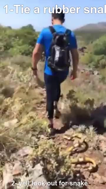 friend ties a rubber snake to his backpack