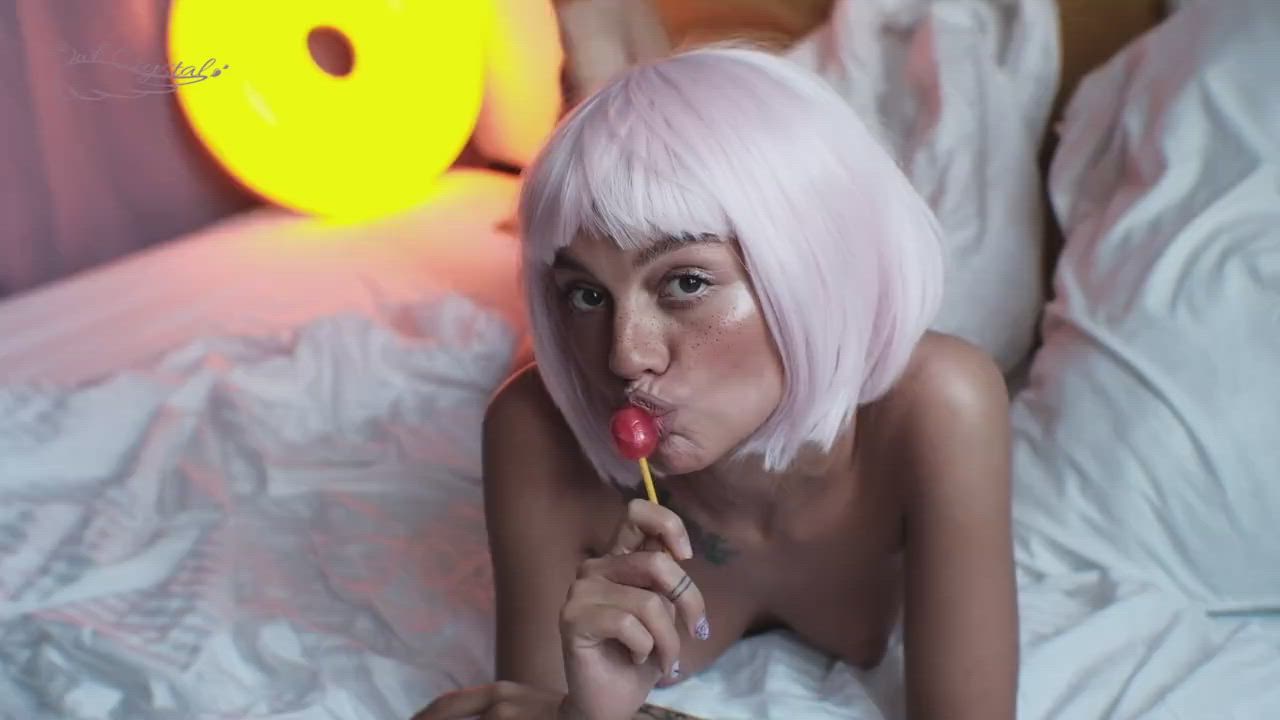Girl with Pink Hair Sucks a Lollipop