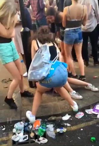 Girl pees on a street in the middle of a watching crowd