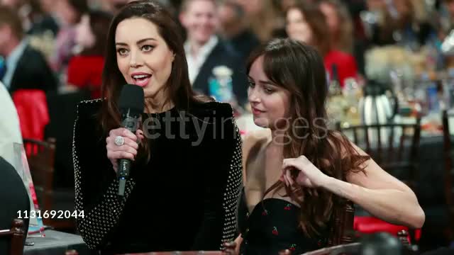 Aubrey Plaza on Dakota Johnson's lap at the 2019 Film Independent Spirit Awards