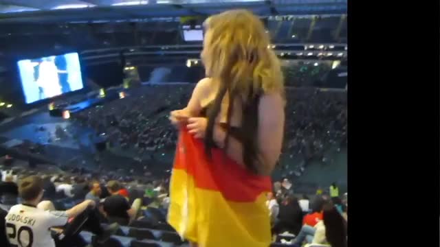 German girl flashes from the last row in a stadium