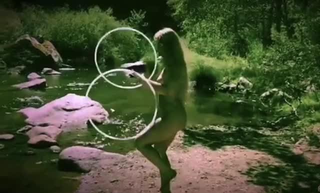 Naked hula hooping by the river