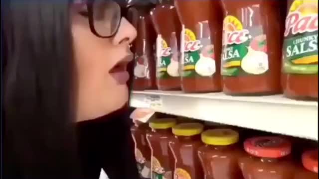 Woman burps on products in a supermarket