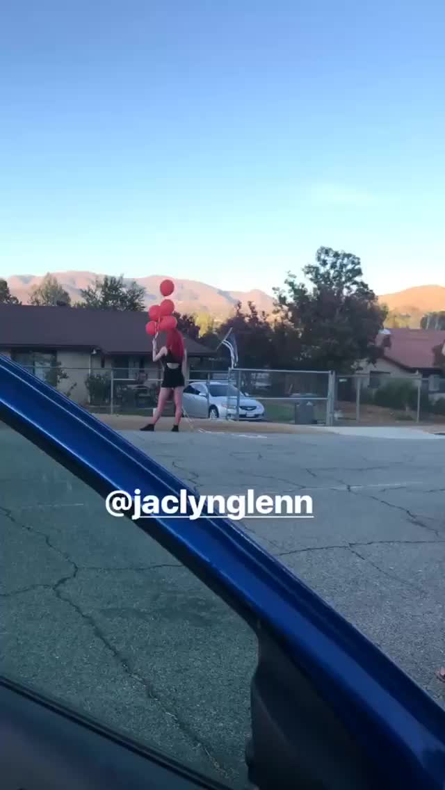 Jaclyn Glenn in a black dress releasing balloons